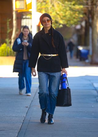 Katie Holmes walks in Soho wearing a gold belted coat cap and boots for her birthday