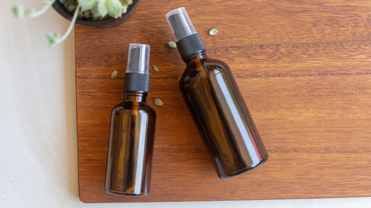 Amber spray bottles on wooden background