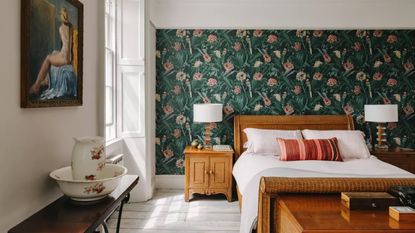 A bedroom in a historic house in bath with green floral wallpaper and a wooden bed
