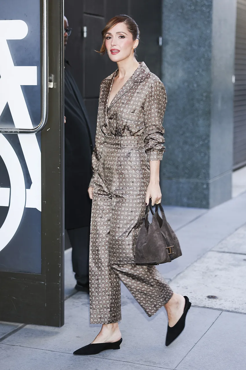 A woman wears closed-toe wedge mules with a matching pants set.