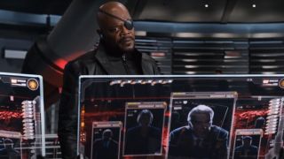 Samuel L Jackson stands in front of monitors with a look of argument in The Avengers.