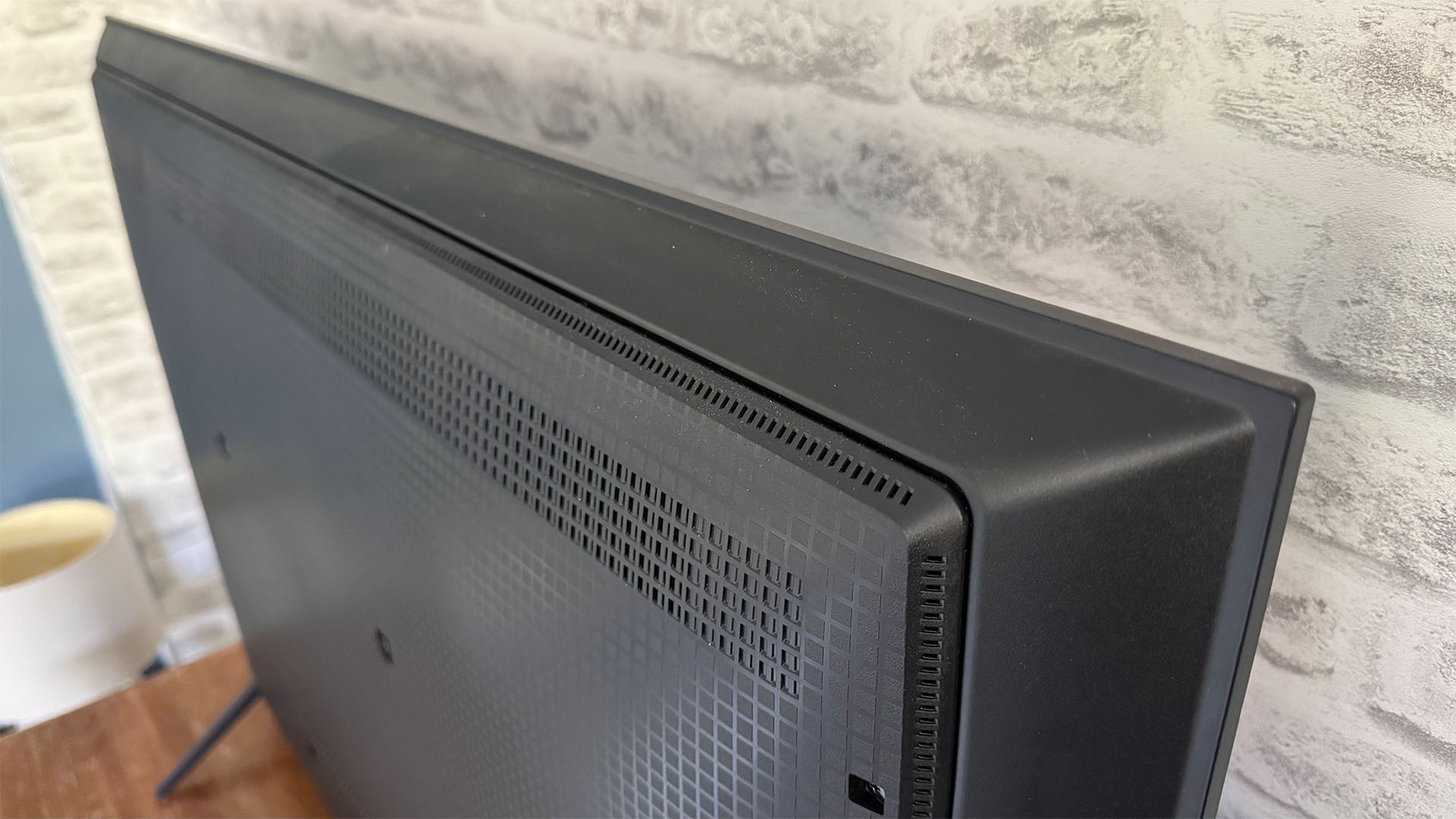 TCL C6KS 50-inch TV in front of brick wall, elevated view of top and rear of set