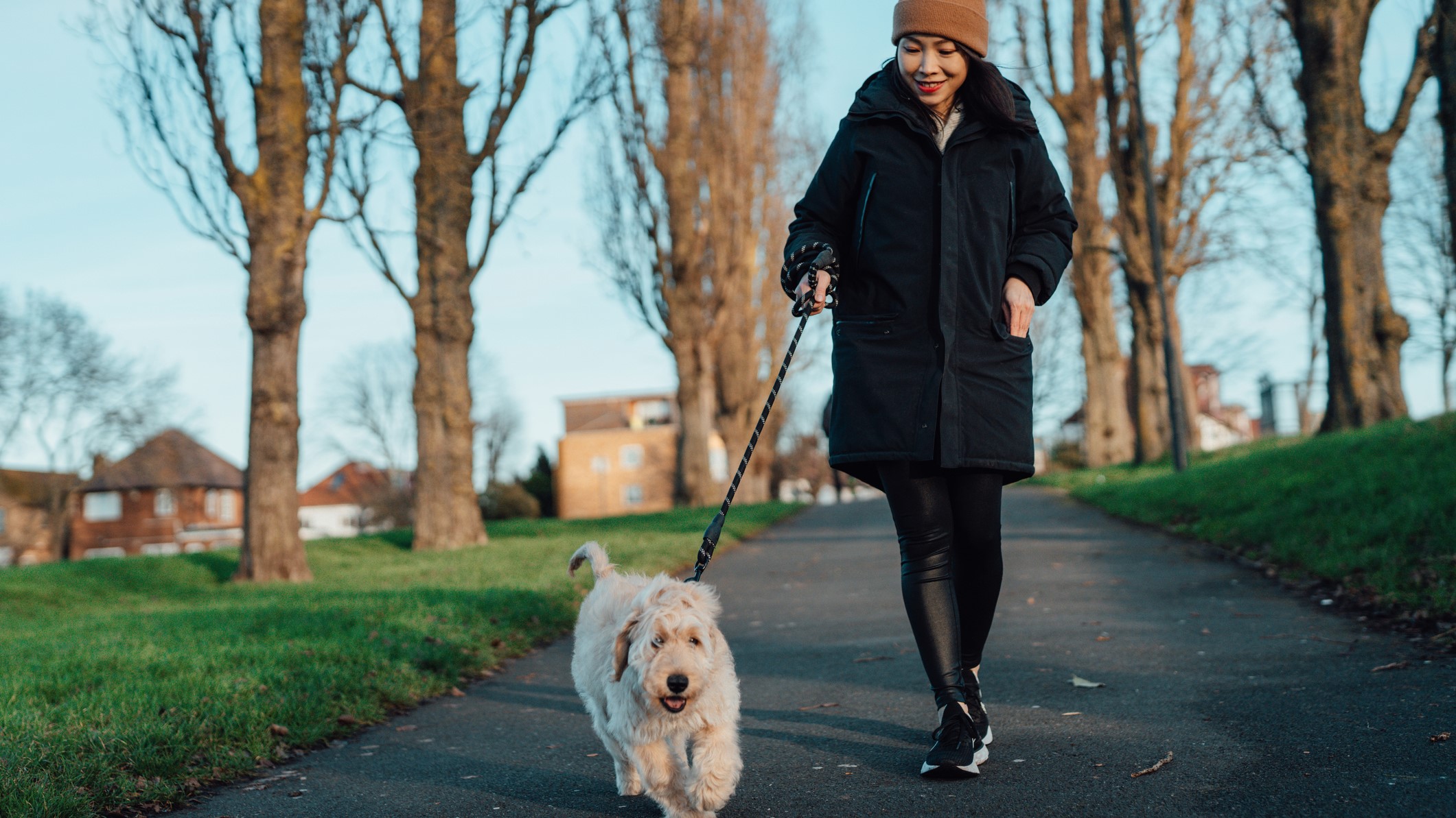 uma foto de uma mulher passeando com um cachorro