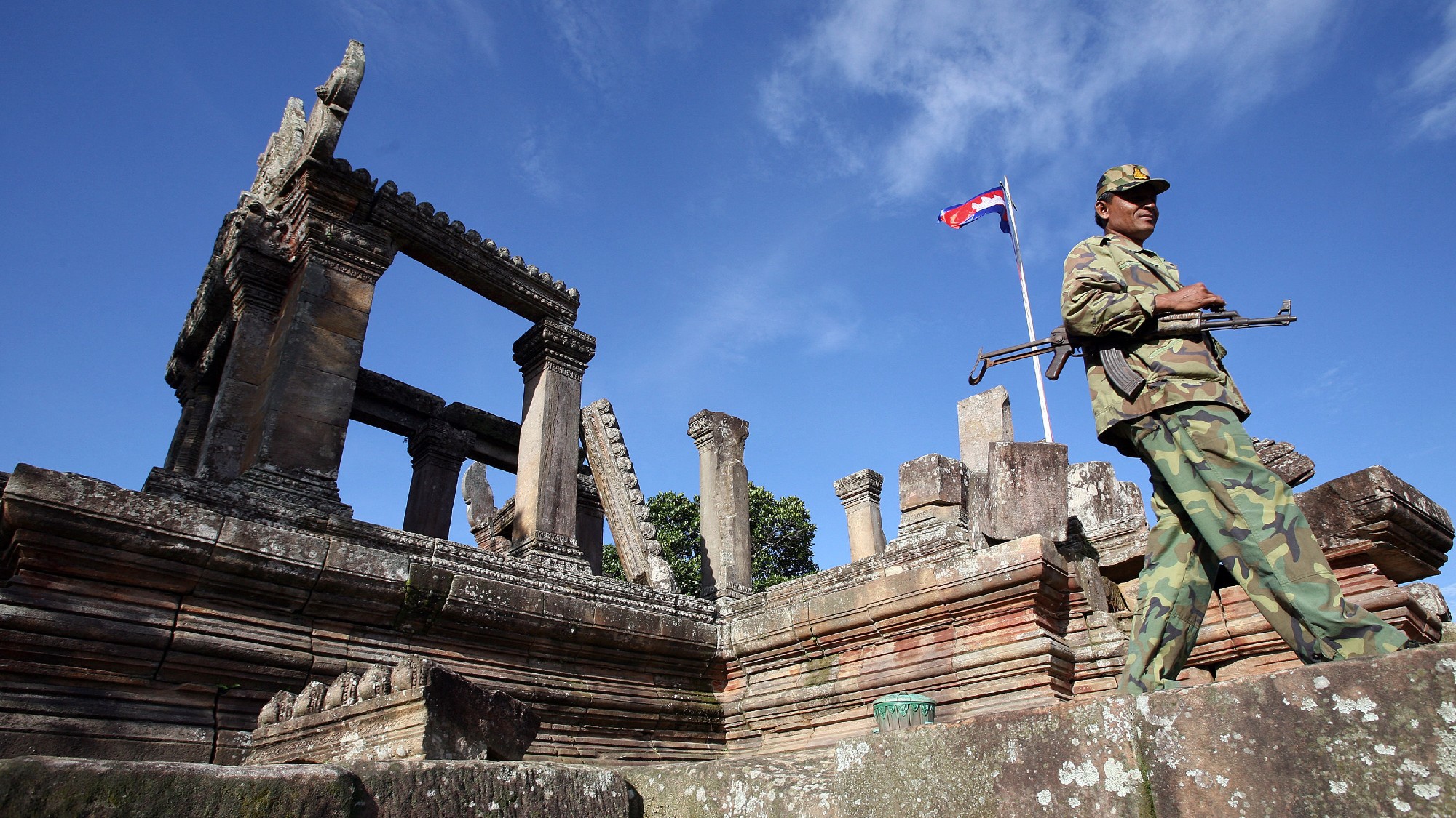 Armed soldier walks along temple ruins