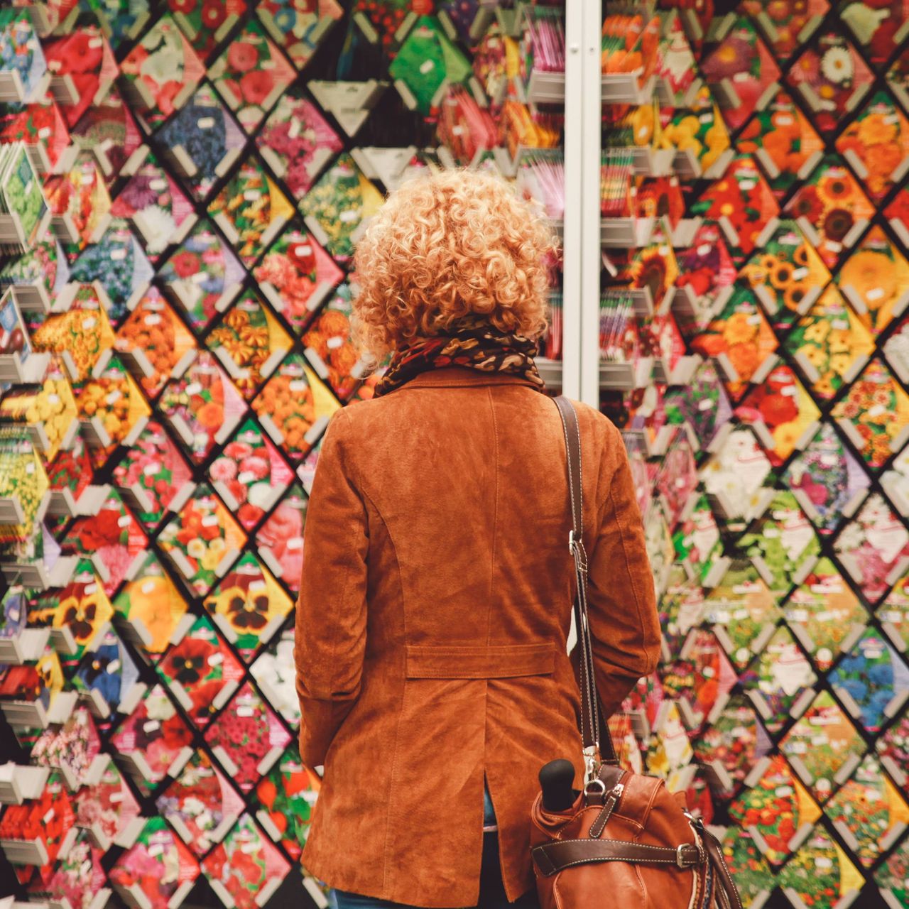 The back of a woman looking at walls of seeds for sale