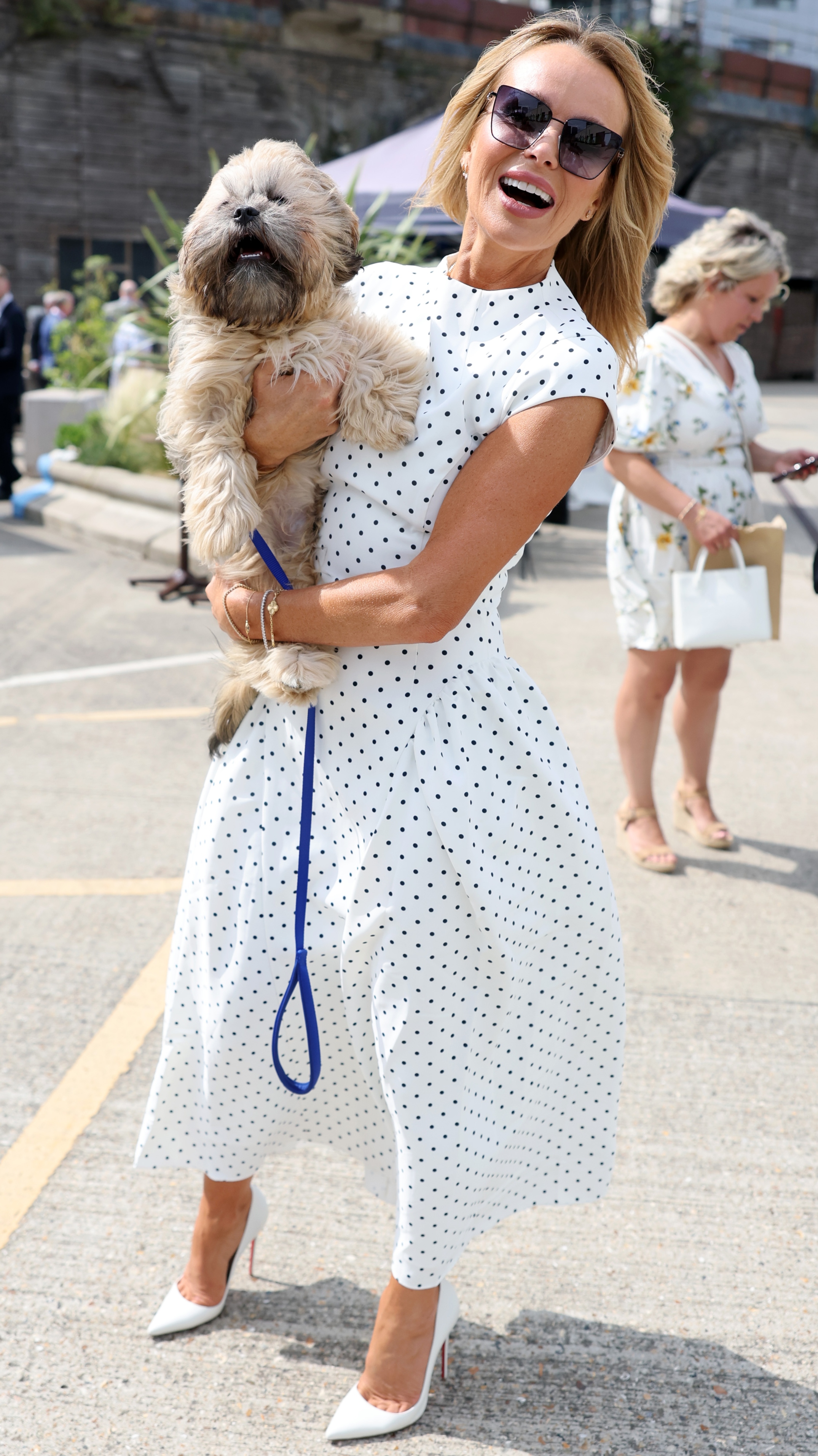 Amanda Holden holds a dog, Chewy, during a visit to unveil the new RHS and BBC Radio 2 'Dog Garden', designed by Monty Don at Battersea Dogs & Cats Home on July 14, 2025