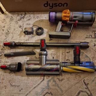 The Dyson V15 Detect Absolute with its four attachments on the floor