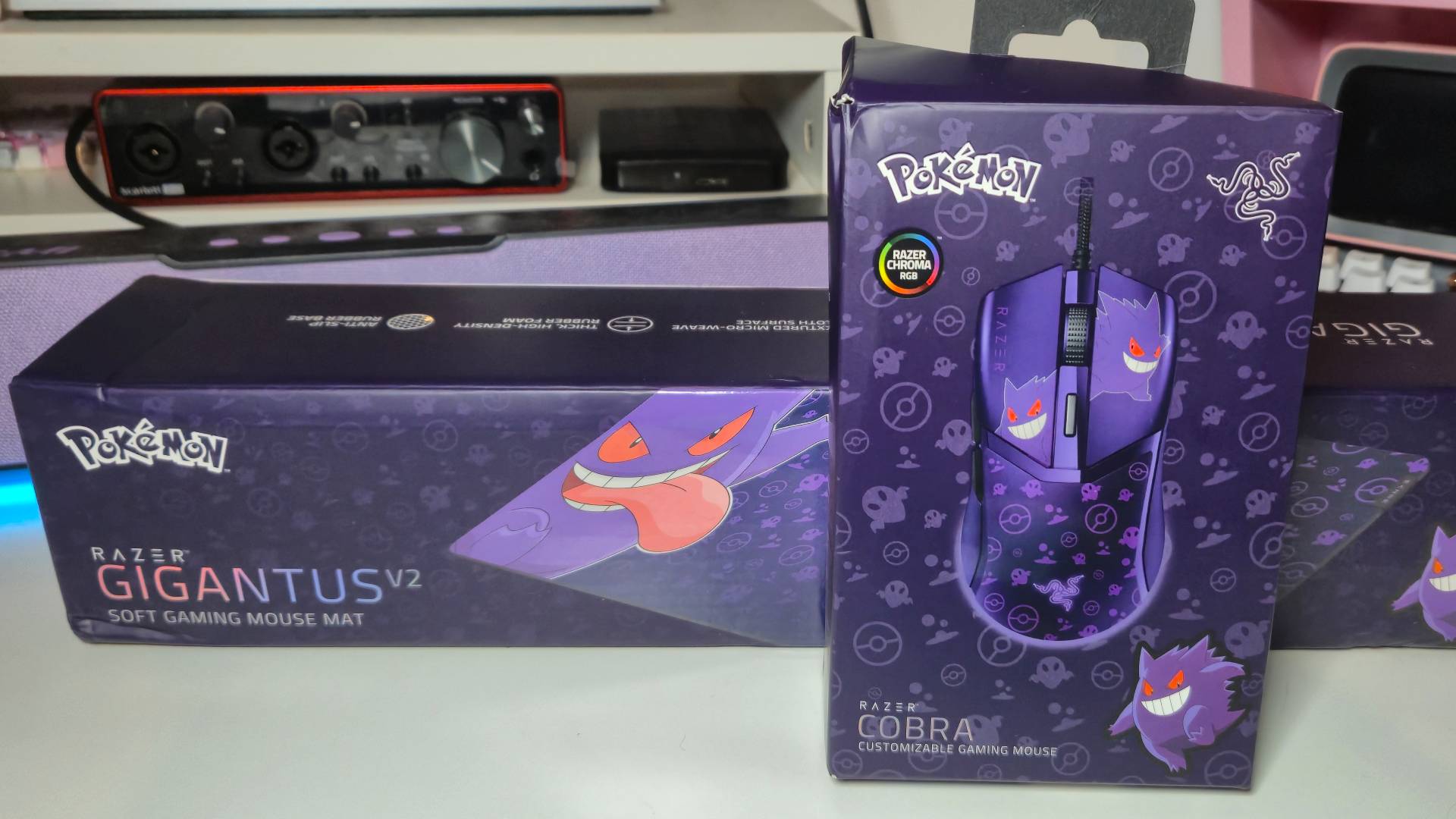 Photo of the Razer Gengar Gigantus v2 mousemat and Cobra gaming mouse product boxes, which are both sitting on a white desk.