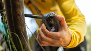 GoPro Hero13 Black camera being used to take a photo by a person in a yellow jacket