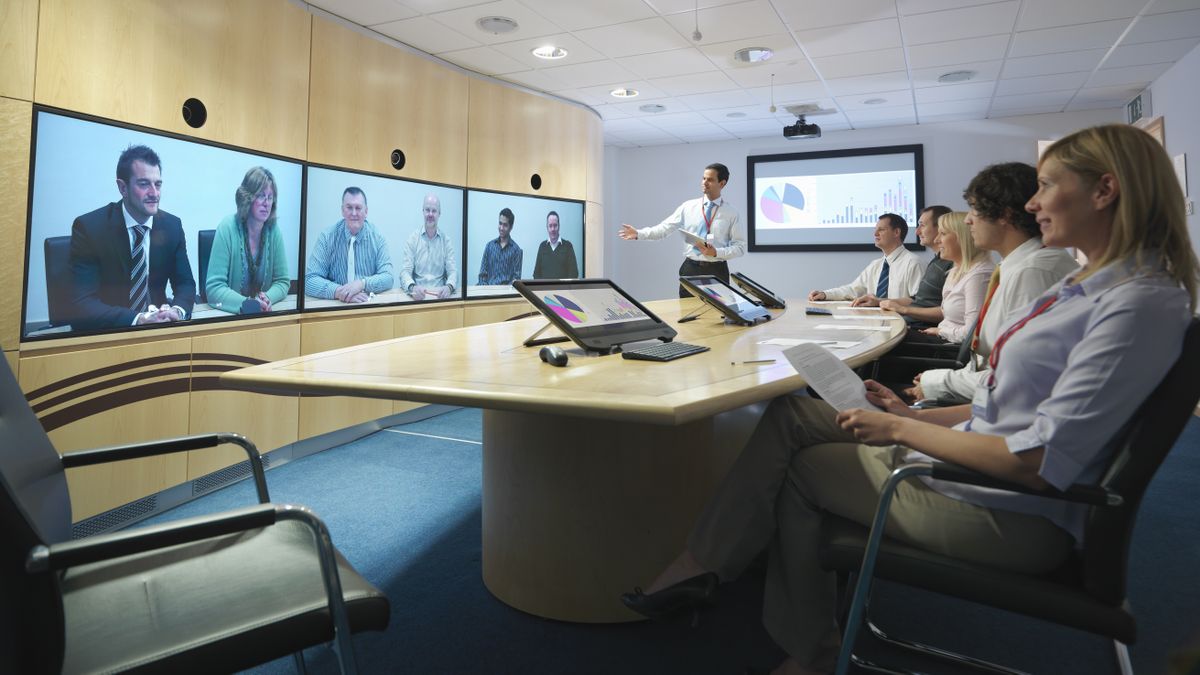 Businesspeople in meeting room taking part in video conference