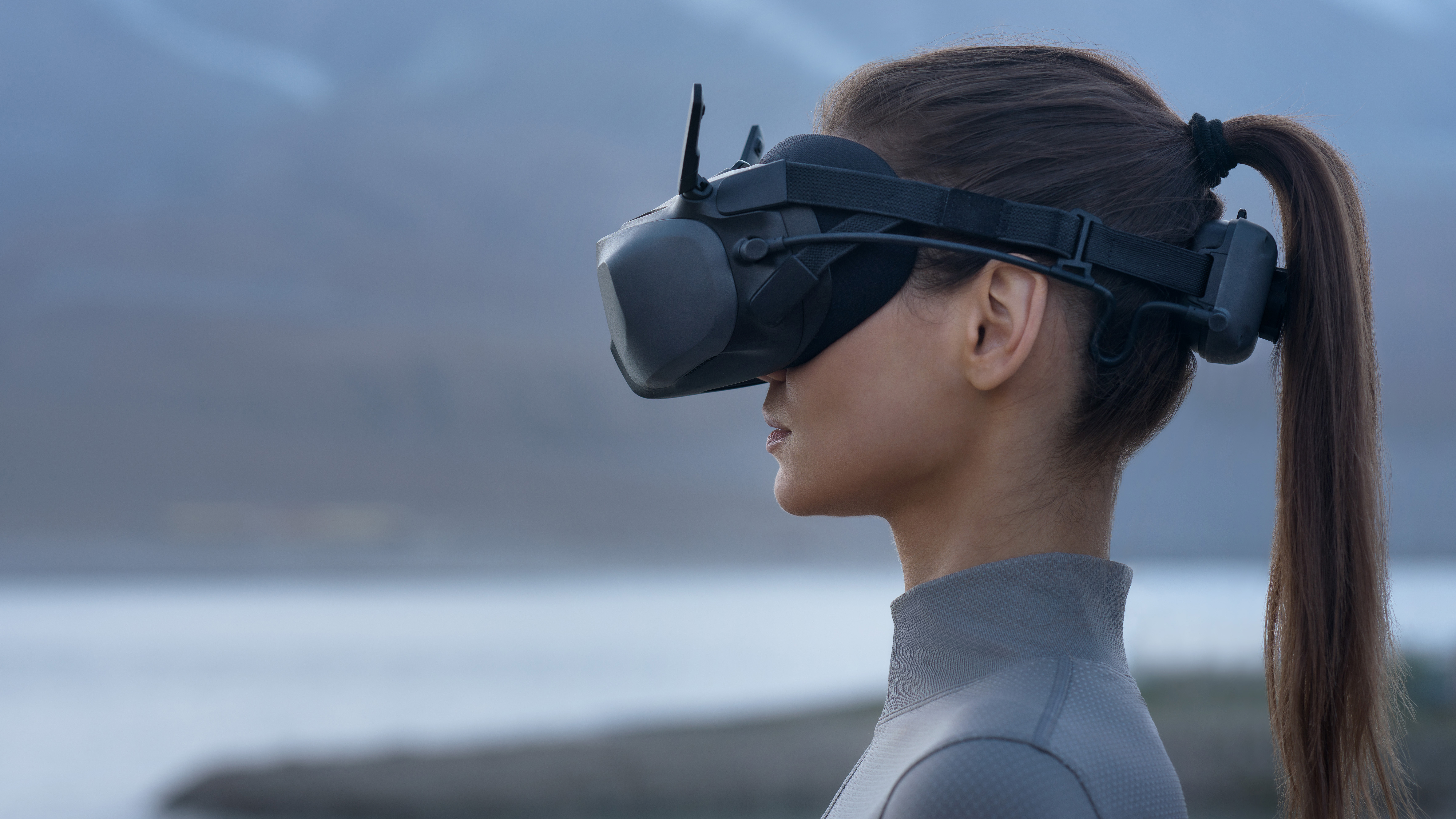 Person wearing DJI Goggles N3 seen from the side with a lake to the background