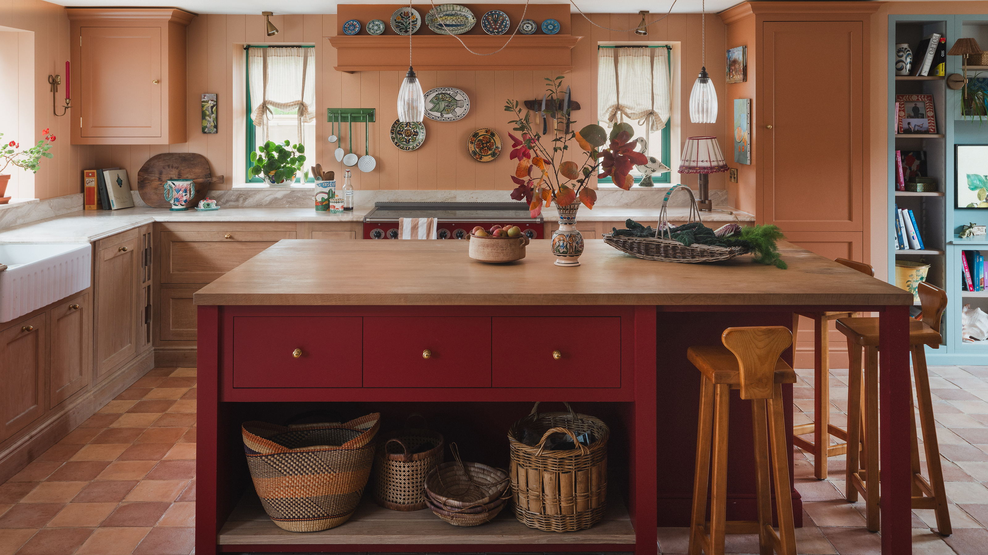 Kitchen with red island and coral walls