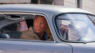 James Bond sitter i en bil och kollar ut mot något i No Time To Die