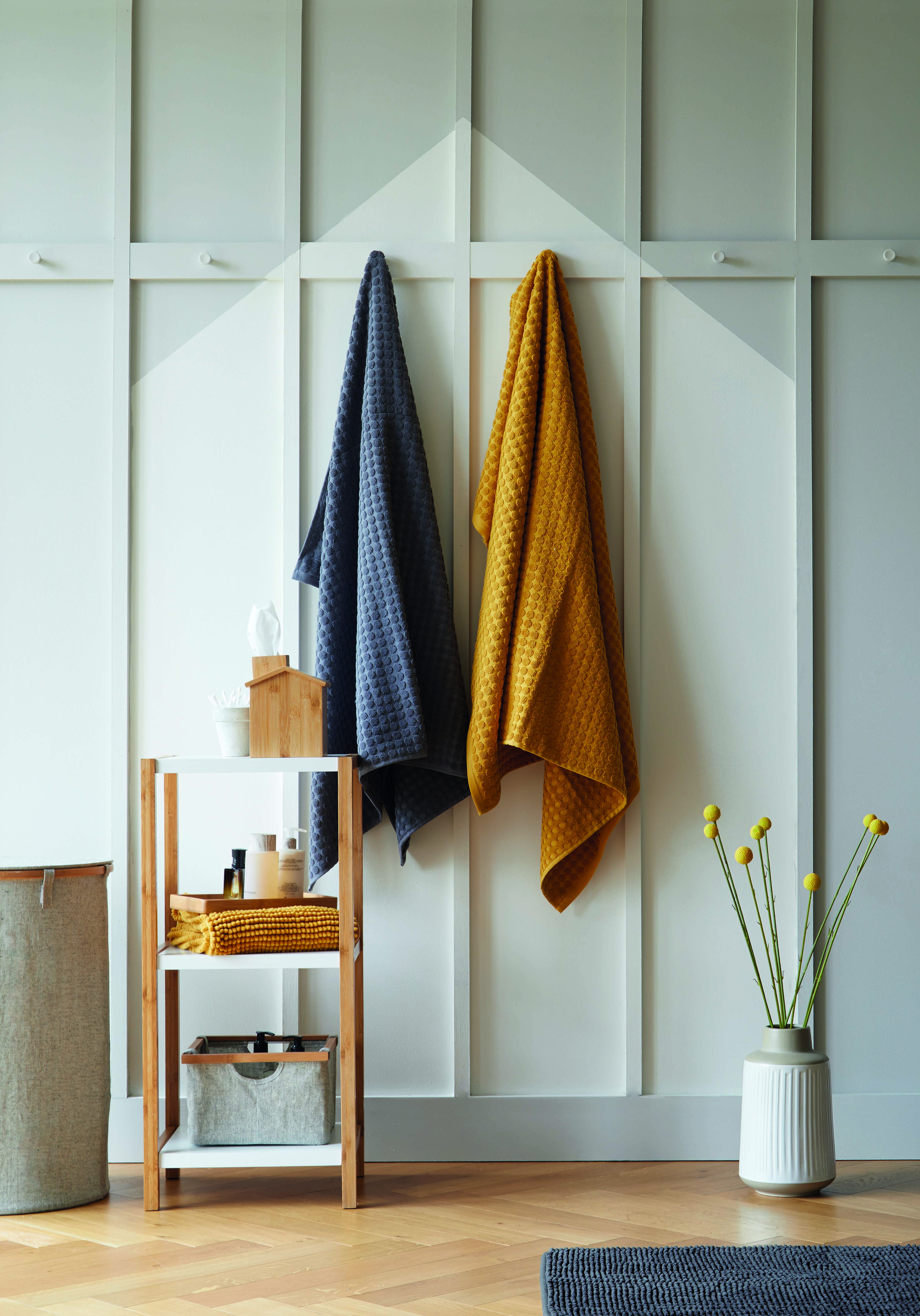 colour blocking paint effect in bathroom with hanging towels and storage unit