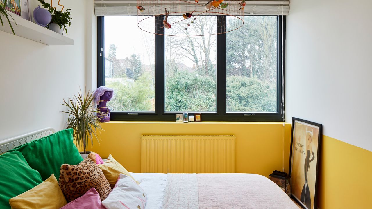 Bedroom with yellow and white colour block wall, black steel windows