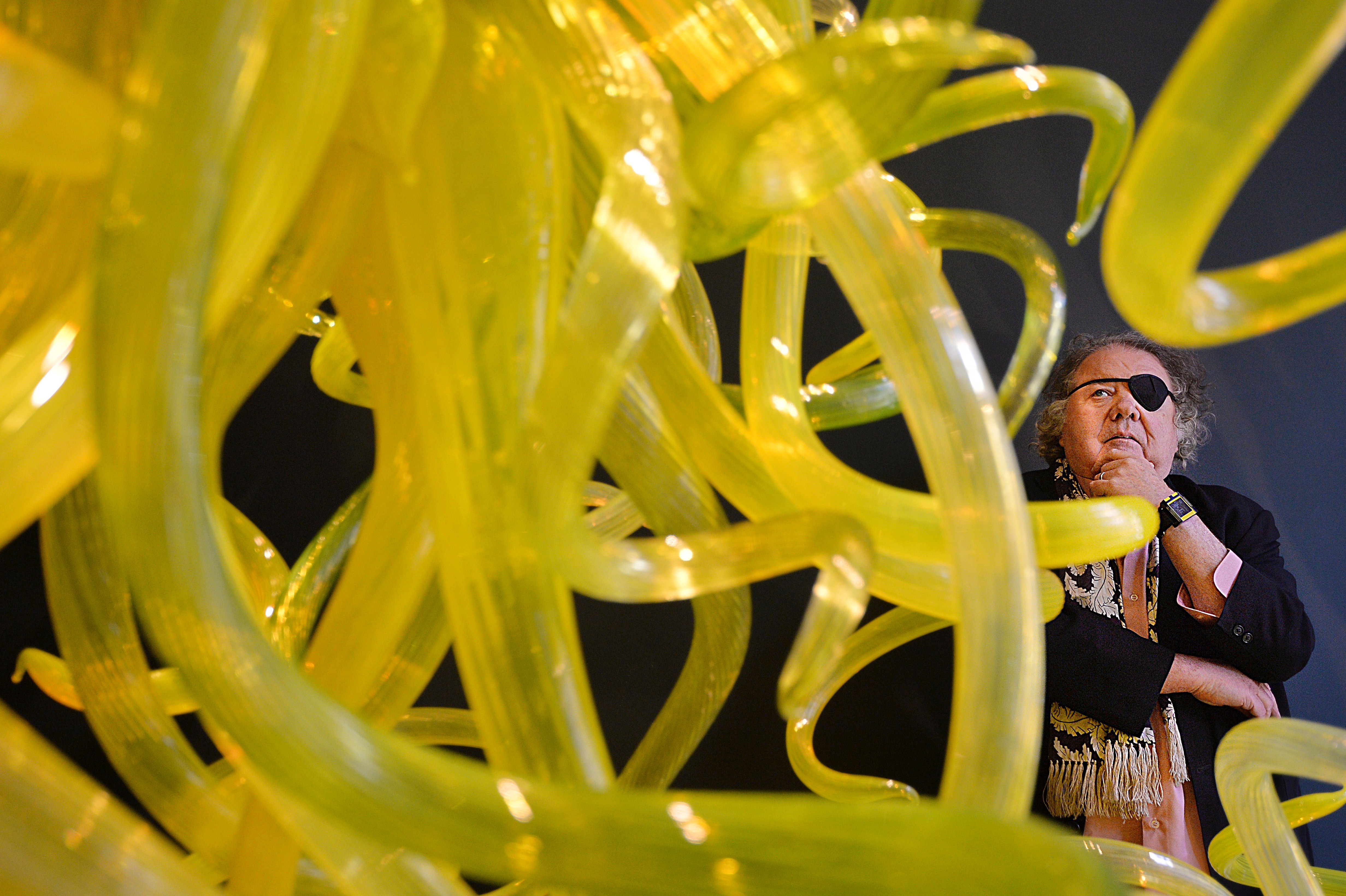 Dale Chihuly poses for a picture with his piece 'Citron Chandelier' in London, 2014.