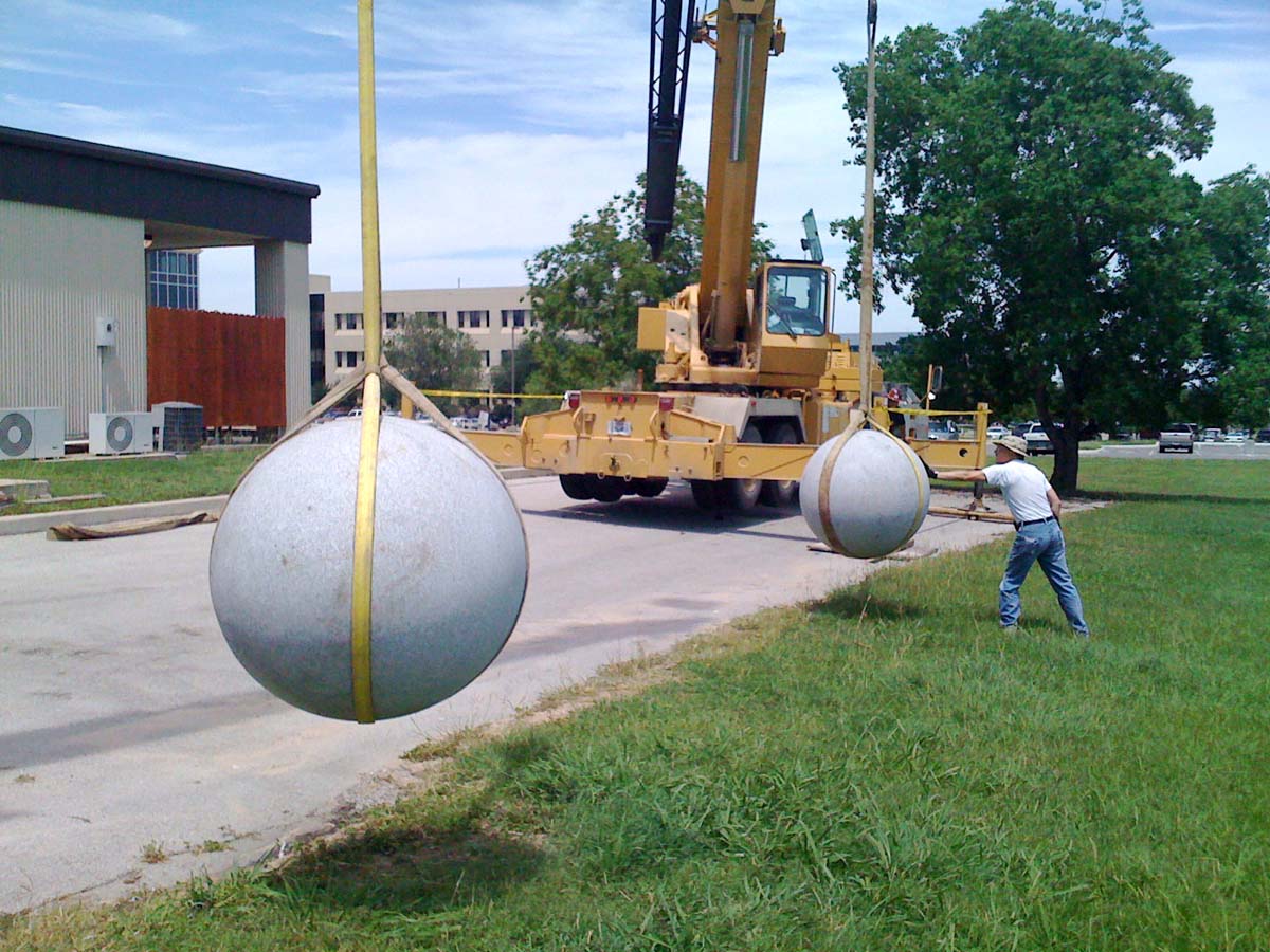 40-foot cranes suspend two granite balls, ready for impact.