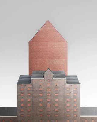 A minimal image of the side of a brick building with a pointed roof