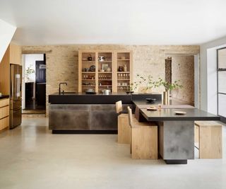 large kitchen with exposed stone wall and L-shaped kitchen island