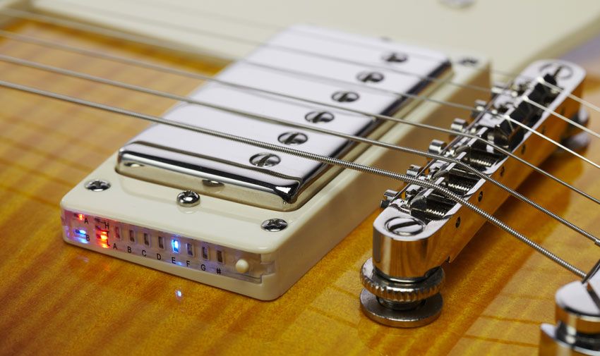 Press a button on the bridge pickup mounting ring to activate the guitar's built-in chromatic tuner