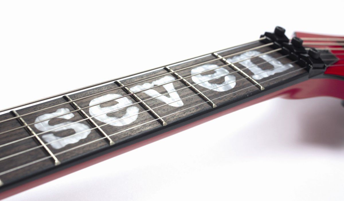 The rosewood fingerboard is inlaid with the legend 'Seven'.