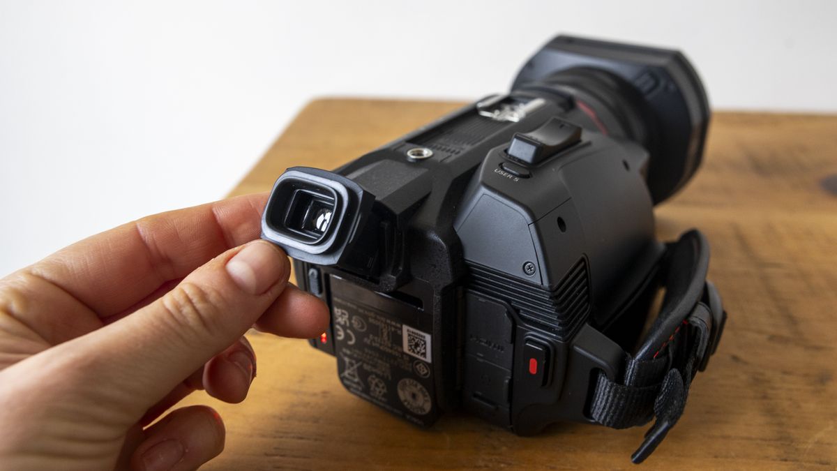 A hand pulling out the viewfinder of the Panasonic HC-X1500 camcorder