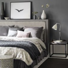 grey bedroom with bed and white lamp
