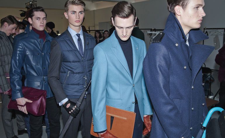 Four men in a line wearing various navy/blue jackets and coats