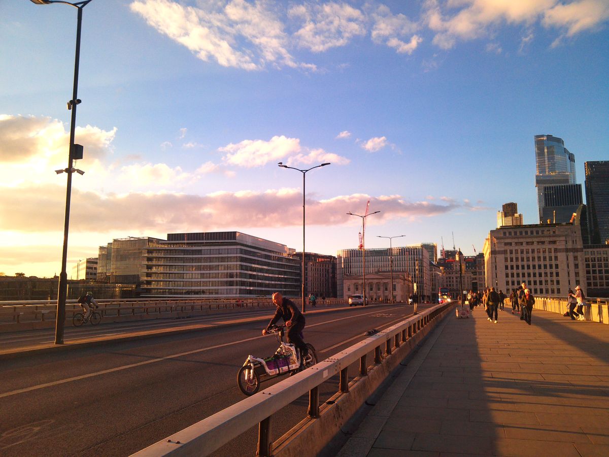 Sample image from Camp Snap CS-Pro digital compact camera showing man on cargo bike swerving on London bridge at sunset