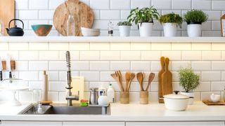 Metro tiles on kitchen wall with shelf and kitchen accessories