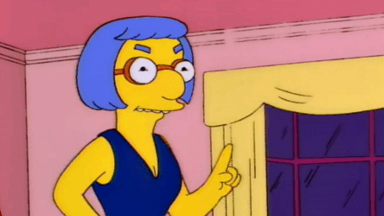 Luann Van Houten holding up a figure and looking angry in The Simpsons