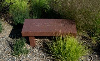 A red granite bench with writing on it.