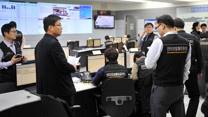 Members of the Korea Internet Security Agency (KISA) check on cyber attacks at a briefing room of KISA in Seoul on March 20, 2013.The South Korean military raised its cyber attack warning lev