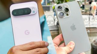 Google Pixel 9 Pro XL in hand showing cameras next to iPhone 15 Pro Max in hand