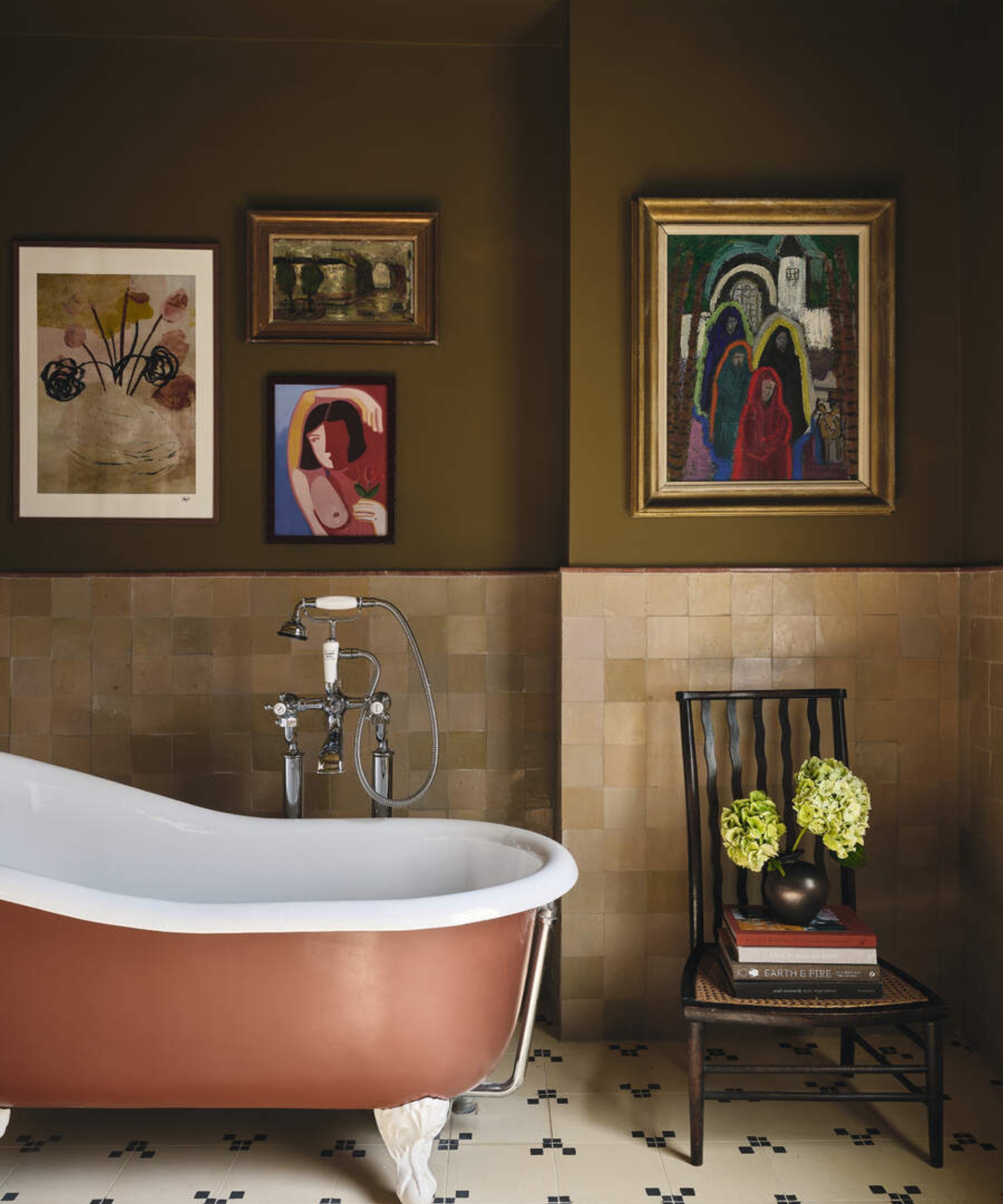 A traditional bathroom with brown walls, beige tiles, and a burnt red bath