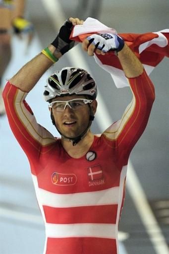 Alex Rasmussen waves the Danish flag for the crowd after delivering the country its first gold medal in the track world championships in Copenhagen.