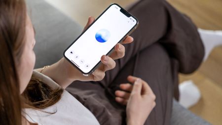 A young woman uses a smartphone to interact with a GPT-based voice.