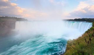 Niagara Falls span the border between the United States and Canada. Though remarkably wide, Niagara is not the tallest or highest-volume waterfall in the world.