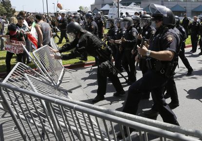 Police officers clash with protesters outside California's Republican Party convention.