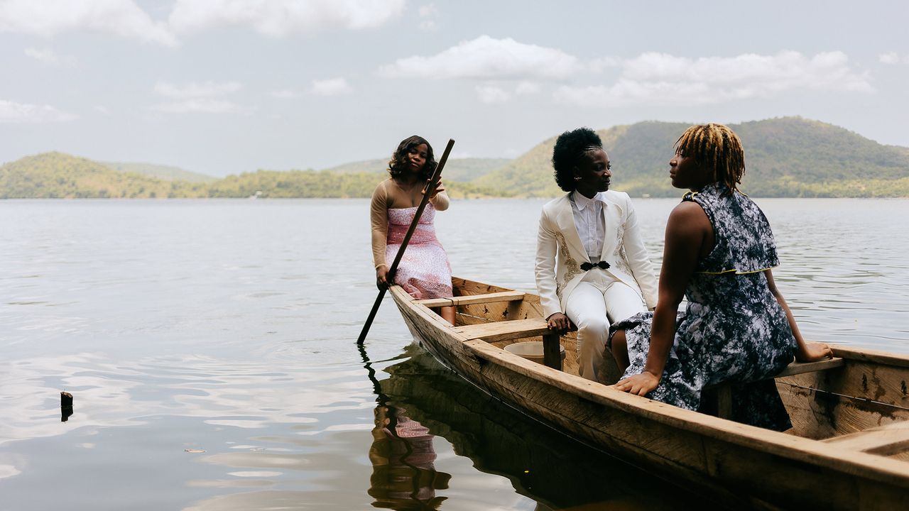 The three girls pose for a proper fashion shoot moment by the river. It is an emotional moment for them, even though posing in the sweltering heat is hard work. 