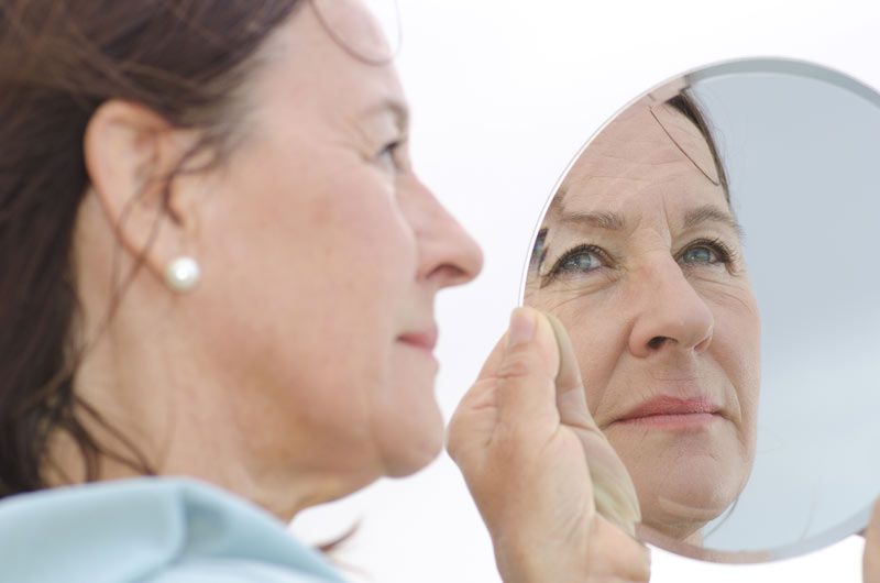 older woman looking in the mirror