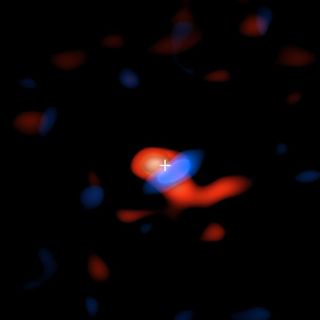 Using radio wave signals, researchers took the first-ever image of the faint, cool ring of hydrogen gas that circles Sagittarius A*. The plus sign represents the black hole, the red coloring represents the gas moving away from our planet and the blue coloring represents the gas moving toward our planet.