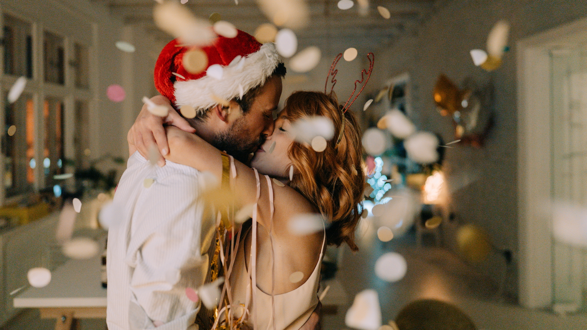 A couple kissing at a Christmas party