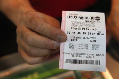 A man hands a customer a Powerball ticket.