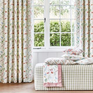 Floral-print curtains with matching cushions on a gingham ottoman