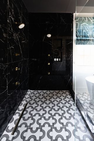 monochromatic shower scheme with black marble walls and black and white floor tiles