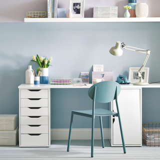 Pastel blue and pink home office, white fitted shelfs, matching desk., built in drawers, grey office chair.