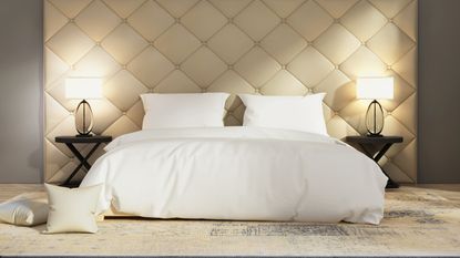 hotel bed with white bedding and fluffy pillows with neutral decor