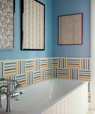 bathroom with blue walls, striped tiles and framed vintage prints