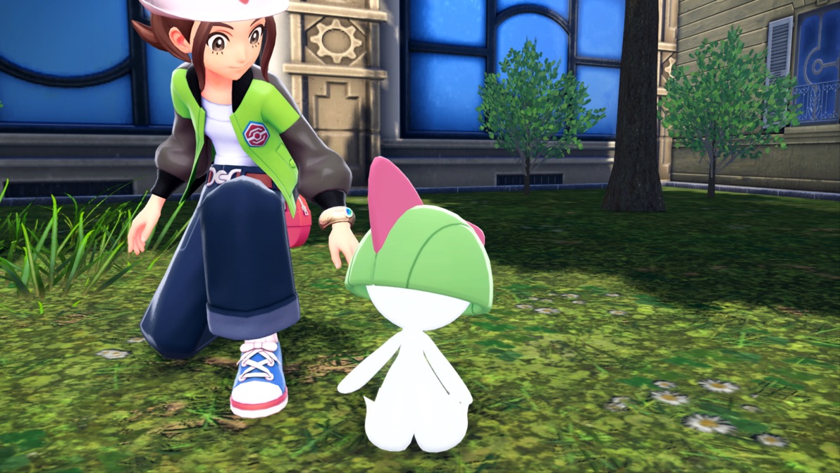 A trainer crouches next to Ralts